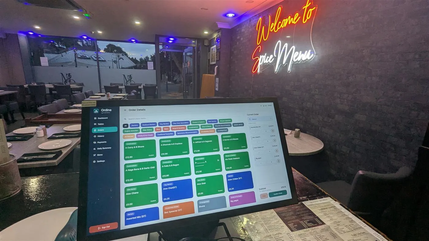 Ordine running on a tablet at the counter of a Birmingham restaurant, with an order being built and the dining room behind it.